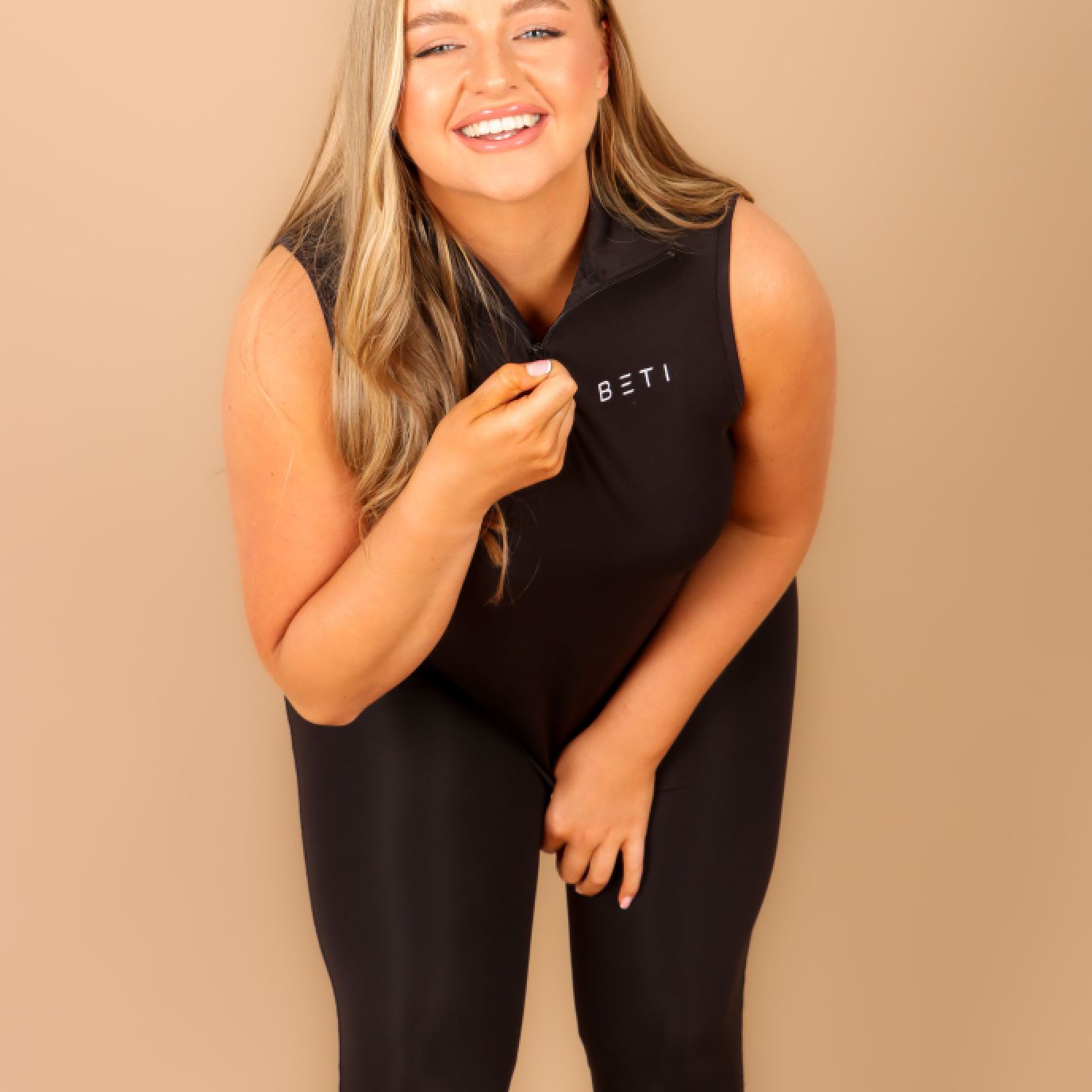 A model wearing the always black three quarters zip up vest and highlighting the use of the zip